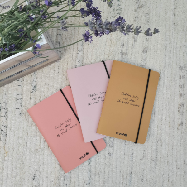 Bodegón con 3 modelos de cuaderno de bolsillo: mostaza, rosa y coral